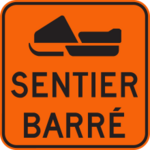 Sign with an orange background showing a snowmobile not allowed on the trail