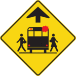 Sign with a yellow background showing a school bus and schoolchildren