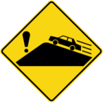 Sign with a yellow background showing a car on an uphill grade and an exclamation mark on the other side of the grade