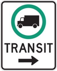 Un panneau rectangulaire contenant un cercle vert dans sa moitié supérieure. À l’intérieur de ce cercle se trouve la silhouette noire d’un camion, vu de côté. Le mot « TRANSIT » se trouve dans la partie inférieure, en majuscules, accompagné d’une flèche noire pointant vers la droite.