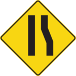 Sign with a yellow background showing a narrowing right lane.